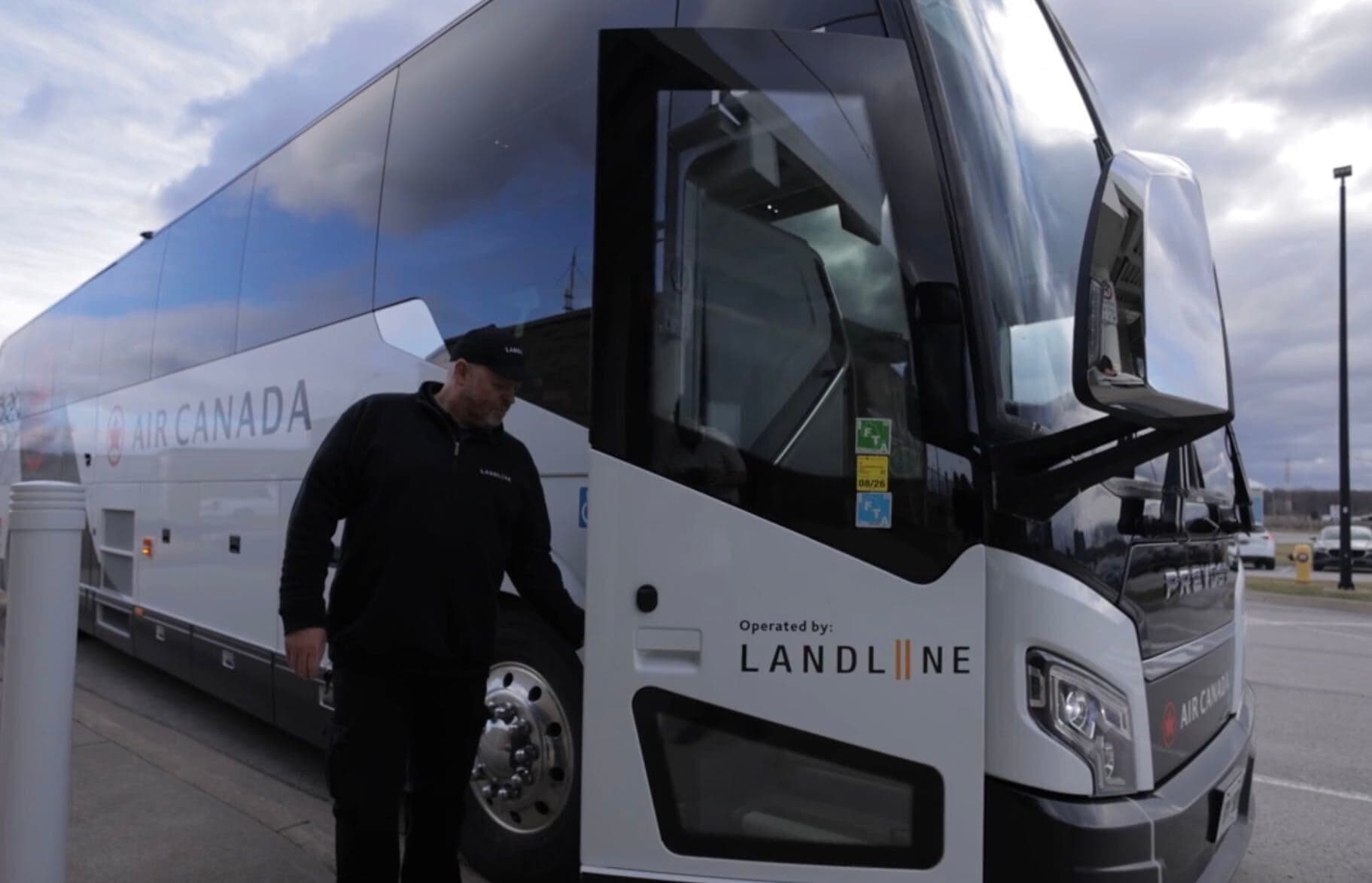 A Landline driver opening the door of an Air Canada coach.